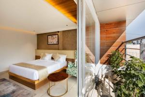 a bedroom with a bed and a balcony at AIRA Boutique Hotel in Bangalore +14 photos