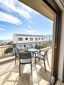 a patio with a table and chairs on a balcony at Fluisterbaai in Britannia Bay