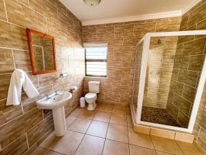 a bathroom with a toilet and a sink and a shower at Fluisterbaai in Britannia Bay +54 photos