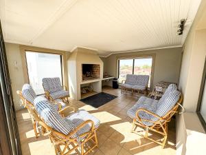 a living room with rocking chairs and a television at Fluisterbaai in Britannia Bay
