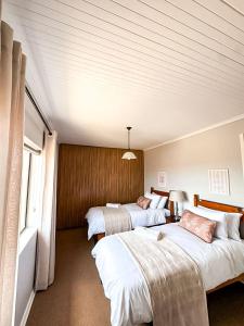 a hotel room with three beds and a window at Fluisterbaai in Britannia Bay