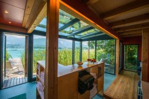 a kitchen with large windows and a view of the water at Kleines Hotel Kärnten in Egg am Faaker See +38 photos