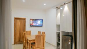 a dining room with a table and a tv on the wall at Winy Home Lovina in Lovina