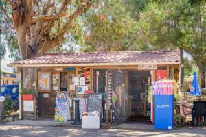 a small store with a sign in front of it at Camping U Pezzo - Mobil home 4 pièces 6/8 personnes Climatisé MAE-2285 in Saint-Florent