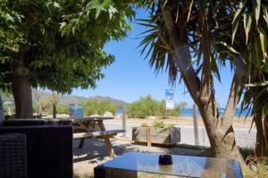a picnic table and a picnic table on the beach at Camping U Pezzo - Mobil home 4 pièces 6/8 personnes Climatisé MAE-2285 in Saint-Florent