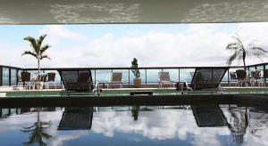 a group of chairs sitting next to a swimming pool at Residence Flat Prime Itaboraí in Itaboraí