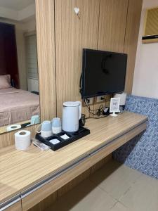 a desk in a room with a television and a bed at Jo Condotels at Persimmon Tower3 in Cebu City
