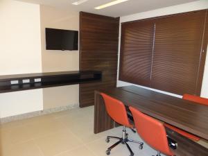 a conference room with red chairs and a wooden table at Residence Flat Prime Itaboraí in Itaboraí +10 photos