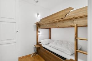 a bunk bed with white sheets on it in a room at Stølstunet Leilighet 617 in Beitostøl