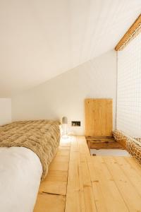 a bedroom with a bed and a wooden floor at Chalet Charm - Private Mountain Retreat with Sauna, Jacuzzi & Kids Playroom in Bansko