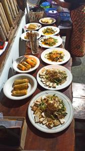 a table with many plates of food on it at Bunga Maliq Bungalow Lombok in Tetebatu