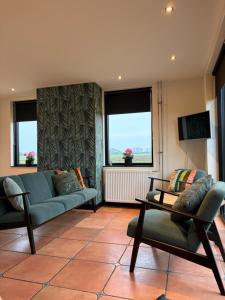 a living room with a couch and chairs and a tv at De Danser 2 in Klaaswaal