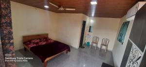 a bedroom with a bed in a room with chairs at Blue Mountain Resorts in Lavasa