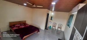 a bedroom with a bed in a room with chairs at Blue Mountain Resorts in Lavasa