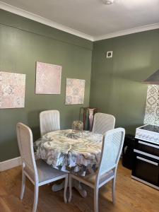 a dining room with a table and four chairs at stylish new house sleeps 5 max in Swansea