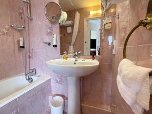 a bathroom with a sink and a shower and a tub and a sink at Hotel Ker Vennaik in Bénodet +38 photos
