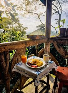 a plate of food on a table with coffee and juice at Cabaña el Leñador in Santa Elena