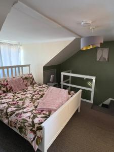 a bedroom with a white bed and green walls at stylish new house sleeps 5 max in Swansea