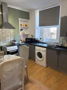 a kitchen with a washer and dryer in it at stylish new house sleeps 5 max in Swansea