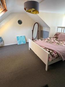 a bedroom with a bed and a mirror on the wall at stylish new house sleeps 5 max in Swansea +10 photos