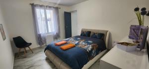 a bedroom with a bed with orange pillows on it at Villa Papillons Narbonne 'Jardin & Clim' 'Proche Centre & Plages' in Narbonne