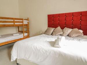 a bedroom with a large white bed with a red headboard at Cottage 3 in Keswick