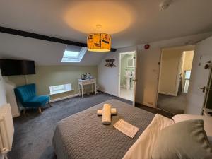 a bedroom with a bed with a teddy bear on it at The Nags Head - Room only accommodation in Lyme Regis