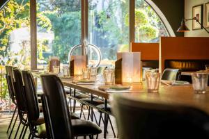 a long table in a restaurant with a large window at Maison Pic in Valence