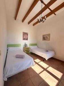 a bedroom with two beds and a ceiling with beams at Son Rapinya Porto Cristo in Porto Cristo +11 photos