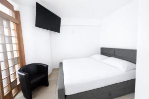 a bedroom with a bed and a black chair at Hotel San Carlo in Lugano