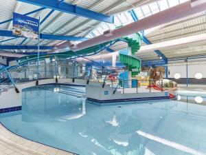 a large swimming pool with a water slide at Pines 15 in Porthcawl