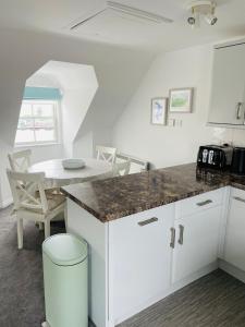 a kitchen with a counter and a table and chairs at Beachfront Retreat in Falmouth