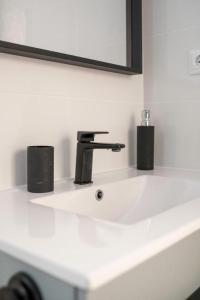 a bathroom sink with a faucet and a mirror at Rodas Apartment in Torrevieja +50 photos