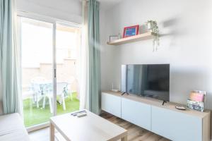 a living room with a large tv and a table at Rodas Apartment in Torrevieja
