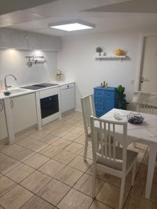 a kitchen with a table and a sink and a table and chairs at Herregårdslejlighed in Vrå