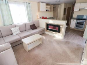 a living room with a couch and a fireplace at Under Cliff Caravan in Ferryside