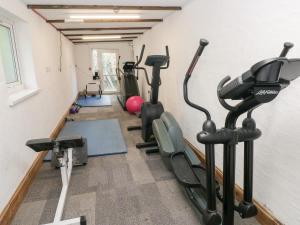 a gym with treadmills and exercise bikes in a room at Under Cliff Caravan in Ferryside +8 photos