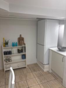 a kitchen with a white refrigerator and a table at Herregårdslejlighed in Vrå +4 photos