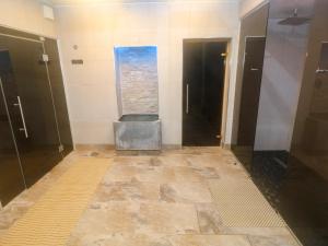 a bathroom with a stone floor and black doors at Under Cliff Caravan in Ferryside