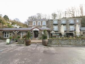 a large stone house with umbrellas in a parking lot at Under Cliff Caravan in Ferryside