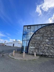 a glass building with a stone wall at No 67 West Road in Fraserburgh