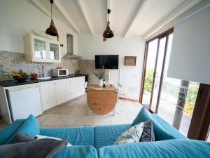 a living room with a blue couch and a kitchen at El Laurel in Frontera