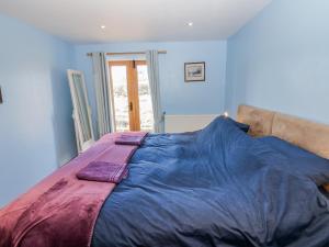 a large blue bed with two pillows on it at Swallows Rest in Hexham