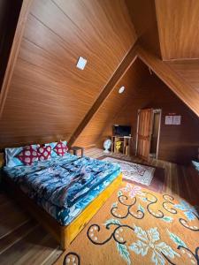 a bed in a room with a wooden ceiling at Holidays homestay in Mirik