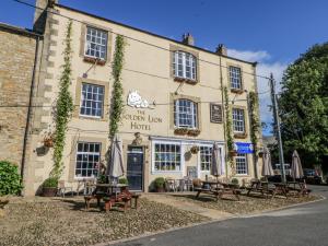 a building with tables and umbrellas in front of it at Swallows Rest in Hexham