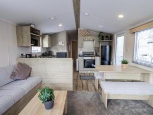 a kitchen and living room with a couch and a table at Hadrian's Rest Glendale Holiday Park in Wigton