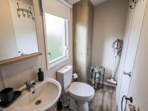 a bathroom with a toilet and a sink and a window at Hadrian's Rest Glendale Holiday Park in Wigton +15 photos