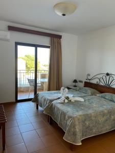 a bedroom with two beds and a sliding glass door at Areti Aparthotel in Áptera +97 photos