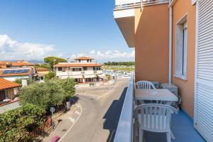 ein Balkon mit Tisch und Stühlen und eine Straße in der Unterkunft Cav Approdo in Castiglione della Pescaia