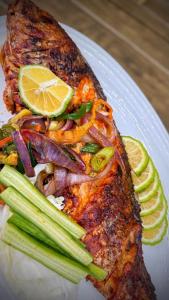 ein Teller mit Essen, einem Stück Fisch und Gemüse in der Unterkunft SV Chrome by AJ Boutique Hotel in Abuja